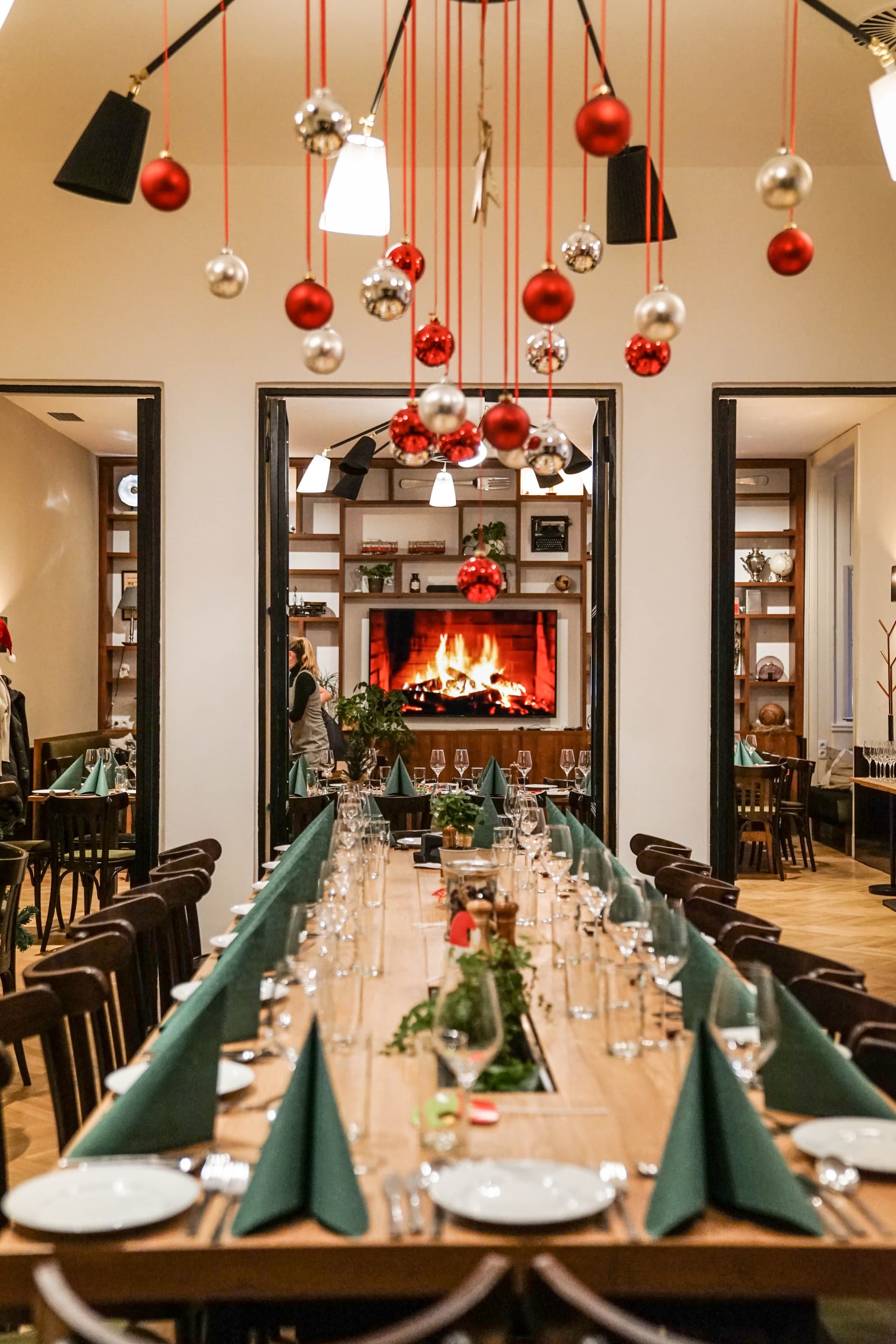 Weihnachtsfeier Salon Wien 1010 - Festlich gedeckte Tafel mit Kamin, Weihnachtskugeln und Weingläsern für Firmenweihnachtsfeier im Café Diglas Schottenstift